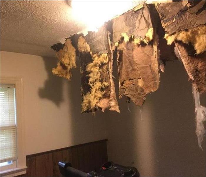 Insulation hanging from damaged ceiling