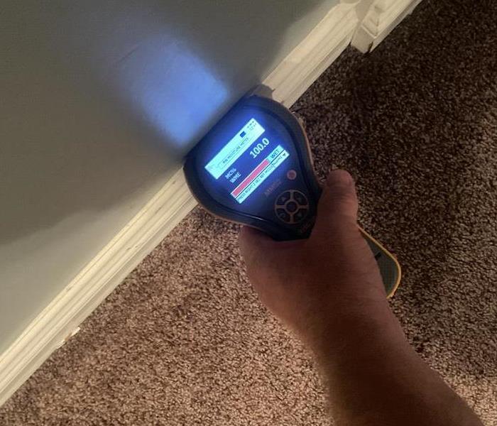 Moisture reader detecting 100% moisture on a wall